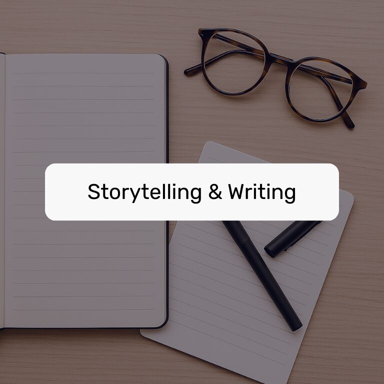 Notebook, glasses, and pens on a wooden desk with a label reading "Storytelling & Writing."