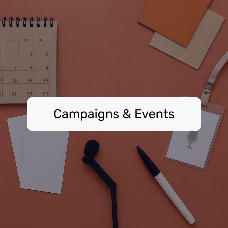 Flat lay of desk items including a calendar, badge, and microphone, labeled "Campaigns & Events."